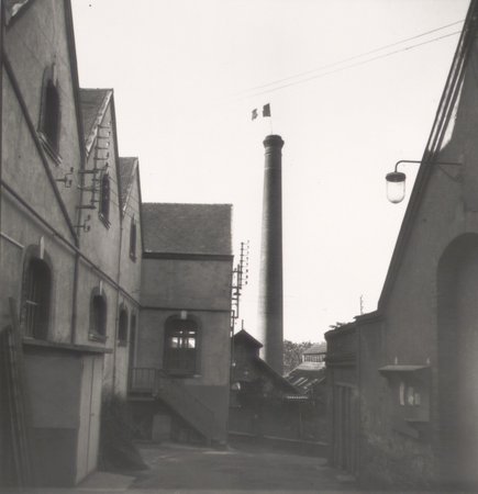 Le drapeau tricolore flotte au sommet de la cheminée d'une fabrique choletaise, 31 août 1944